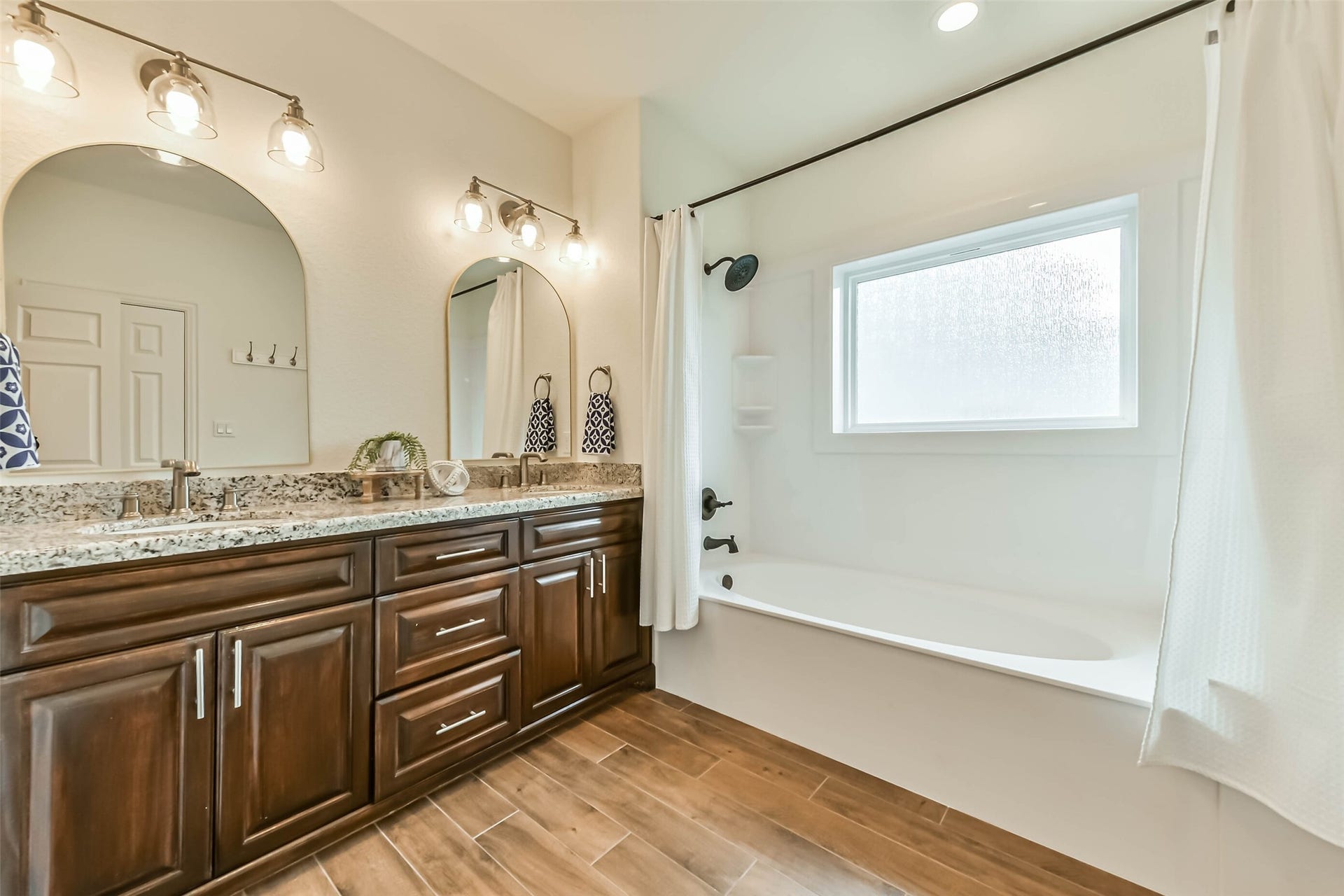 429 Jeanie Lynne Circle, Tiki Island, TX 77554 Neutral tones, stylish lighting, and durable flooring create a clean and functional bathroom environment.