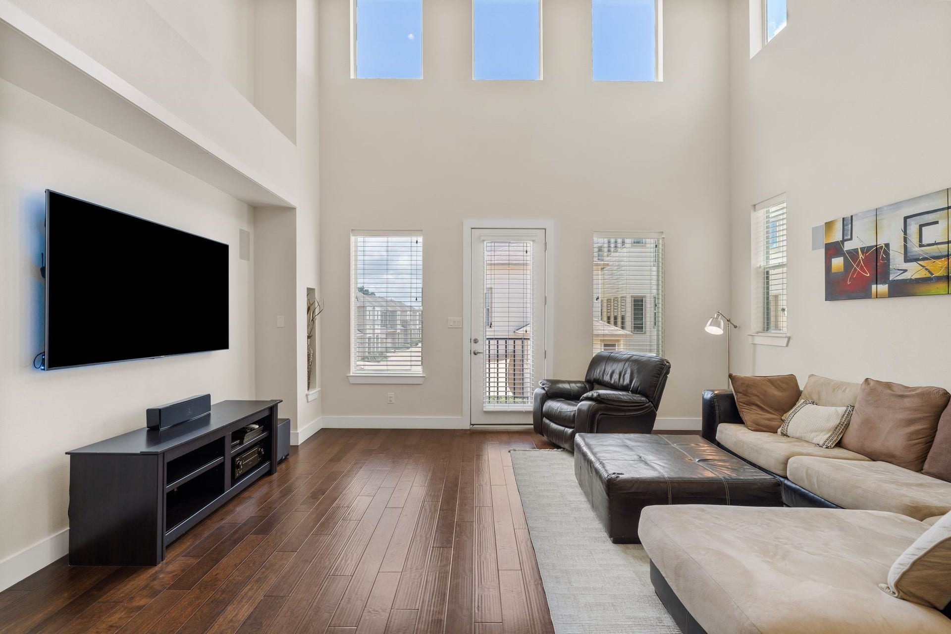 The living room, complete with a charming Juliette balcony that invites the breeze in, flows seamlessly into the dining area and kitchen.