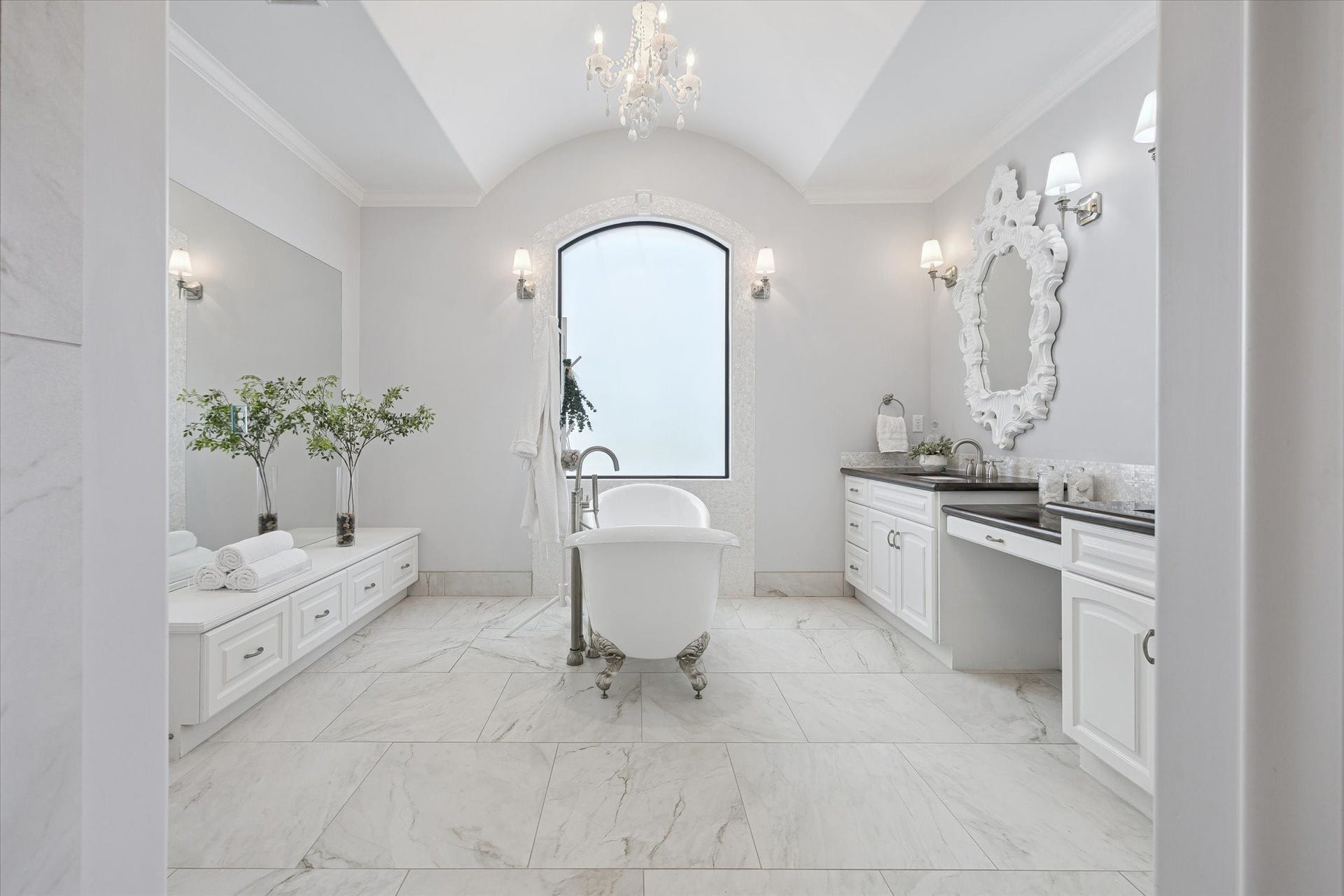 4022 Coleridge Street, West University Place, TX 77005 Spa-inspired primary bath with freestanding soaking tub, double vanities, and elegant finishes. Coordinating walk-in shower with marble tiles, frameless glass enclosure, and built-in bench adds a luxurious functionality to the space.