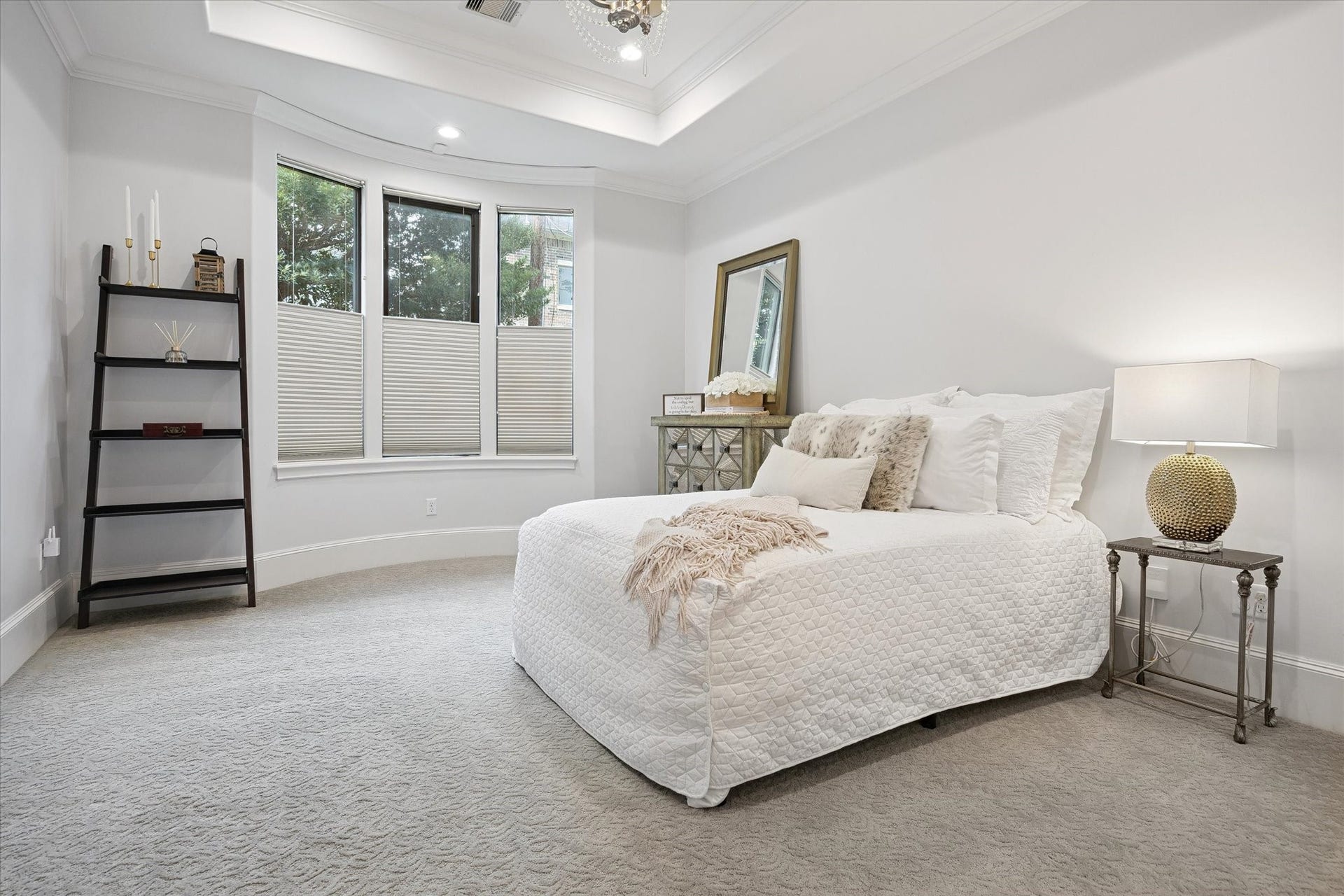 4022 Coleridge Street, West University Place, TX 77005 Spacious first-floor junior suite featuring large windows overlooking the backyard, a tray ceiling with crown molding and chandelier, plush designer carpeting, and refined neutral finishes. The ensuite bedroom offers a luxurious retreat for guests, a private mother-in-law suite, or a convenient executive suite, while the versatile space could also serve as a private home office or downstairs gameroom.