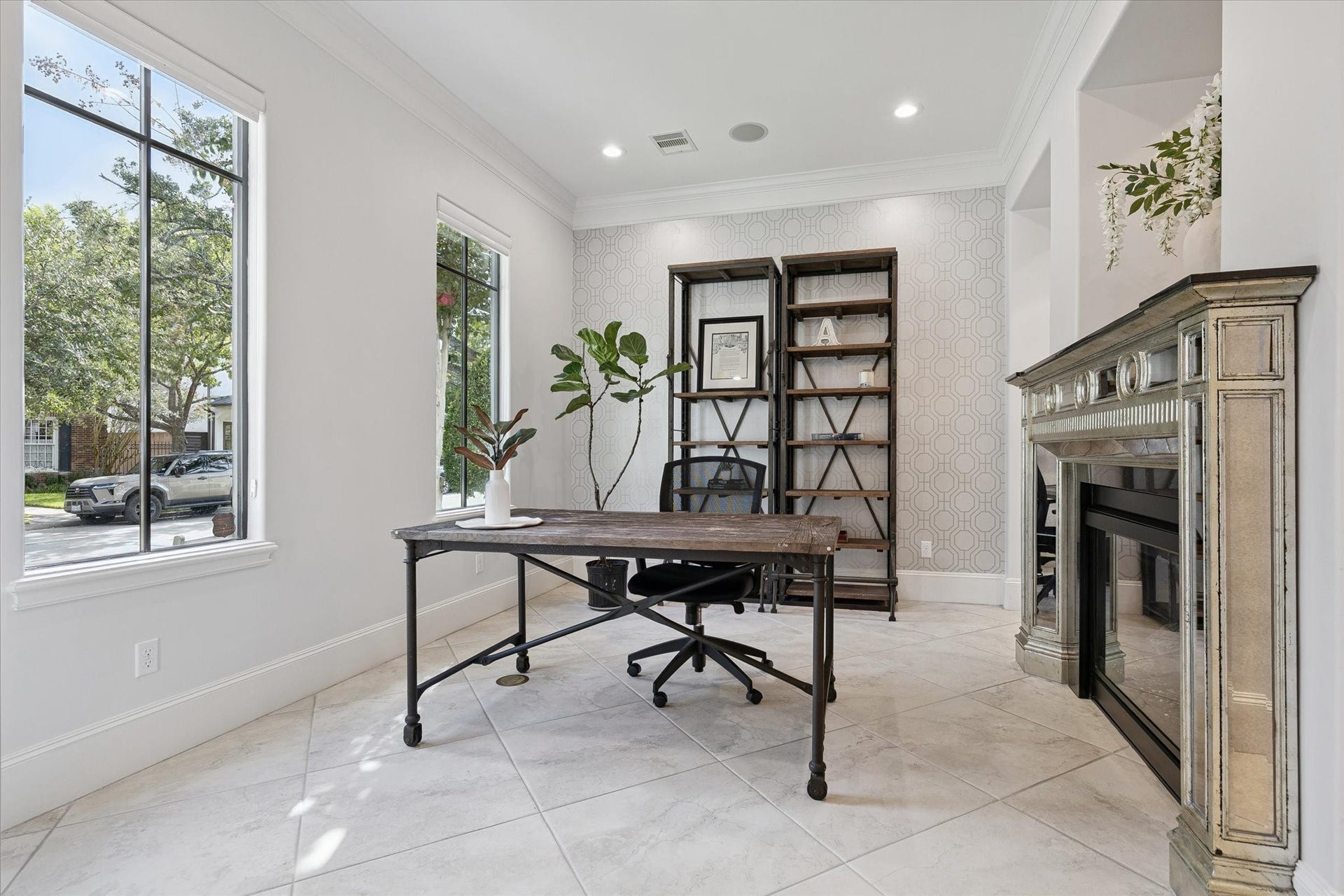 4022 Coleridge Street, West University Place, TX 77005 Elegant formal living area, currently utilized as a formal study. The room's double-sided gas log fireplace, crown molding, recessed lighting, and front-facing windows create a cozy retreat for work or entertaining.