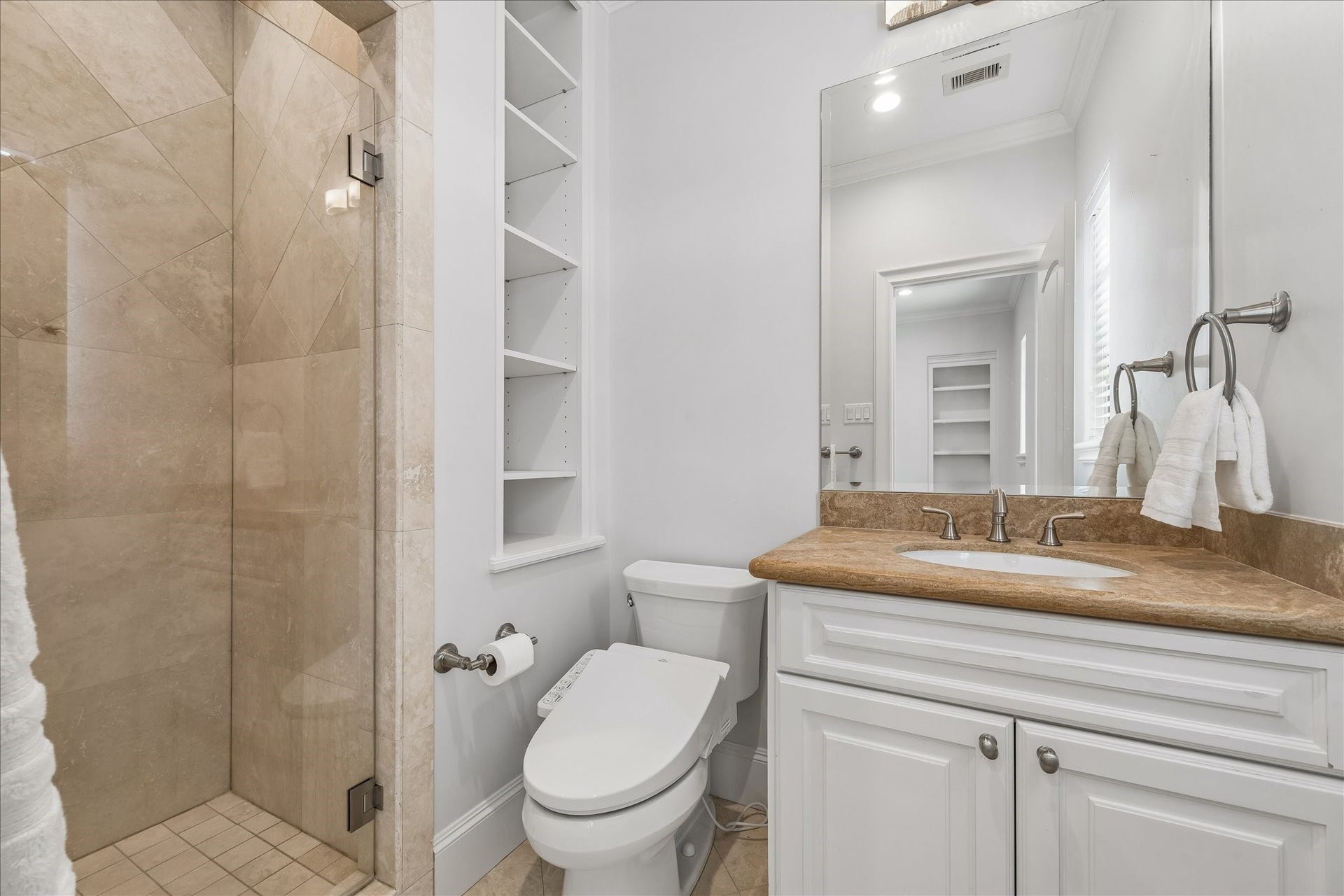 4022 Coleridge Street, West University Place, TX 77005 Well-appointed private secondary bathroom with marble countertops, custom cabinetry, and glass-enclosed shower.
