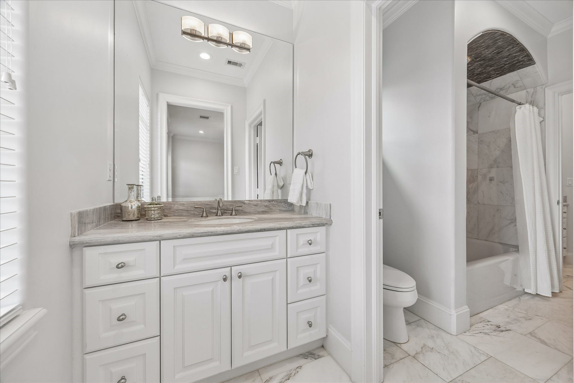4022 Coleridge Street, West University Place, TX 77005 Hollywood-style secondary bathroom showcasing beautiful tile flooring, elegant vanity, and tub/shower combination with designer tile.