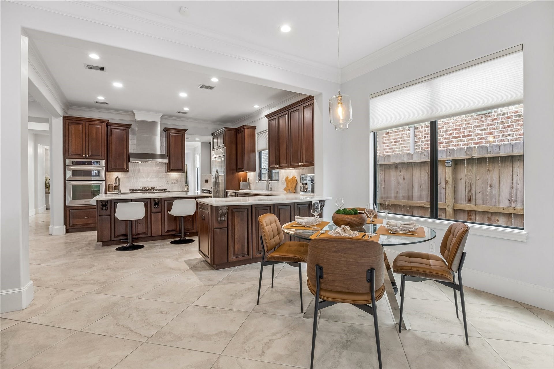4022 Coleridge Street, West University Place, TX 77005 Open kitchen and breakfast area featuring rich wood cabinetry, expansive marble countertops, and views of the outdoor space.