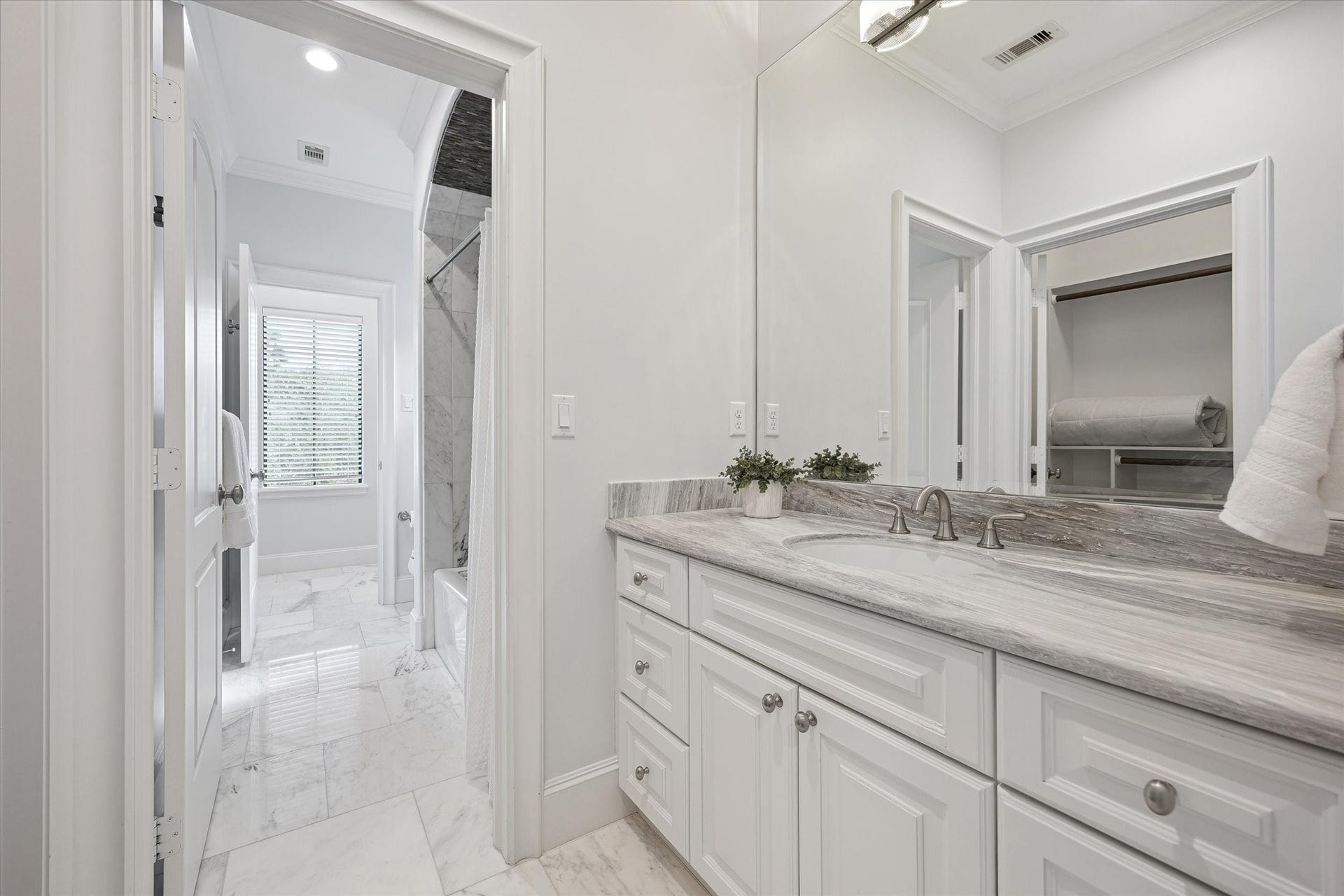 4022 Coleridge Street, West University Place, TX 77005 Alternate view of the secondary bathroom connecting the bedrooms, featuring stone countertops, beautiful tilework, ample storage, and an adjacent walk-in closet. Notably, every bedroom in this well-appointed home includes its own walk-in closet.