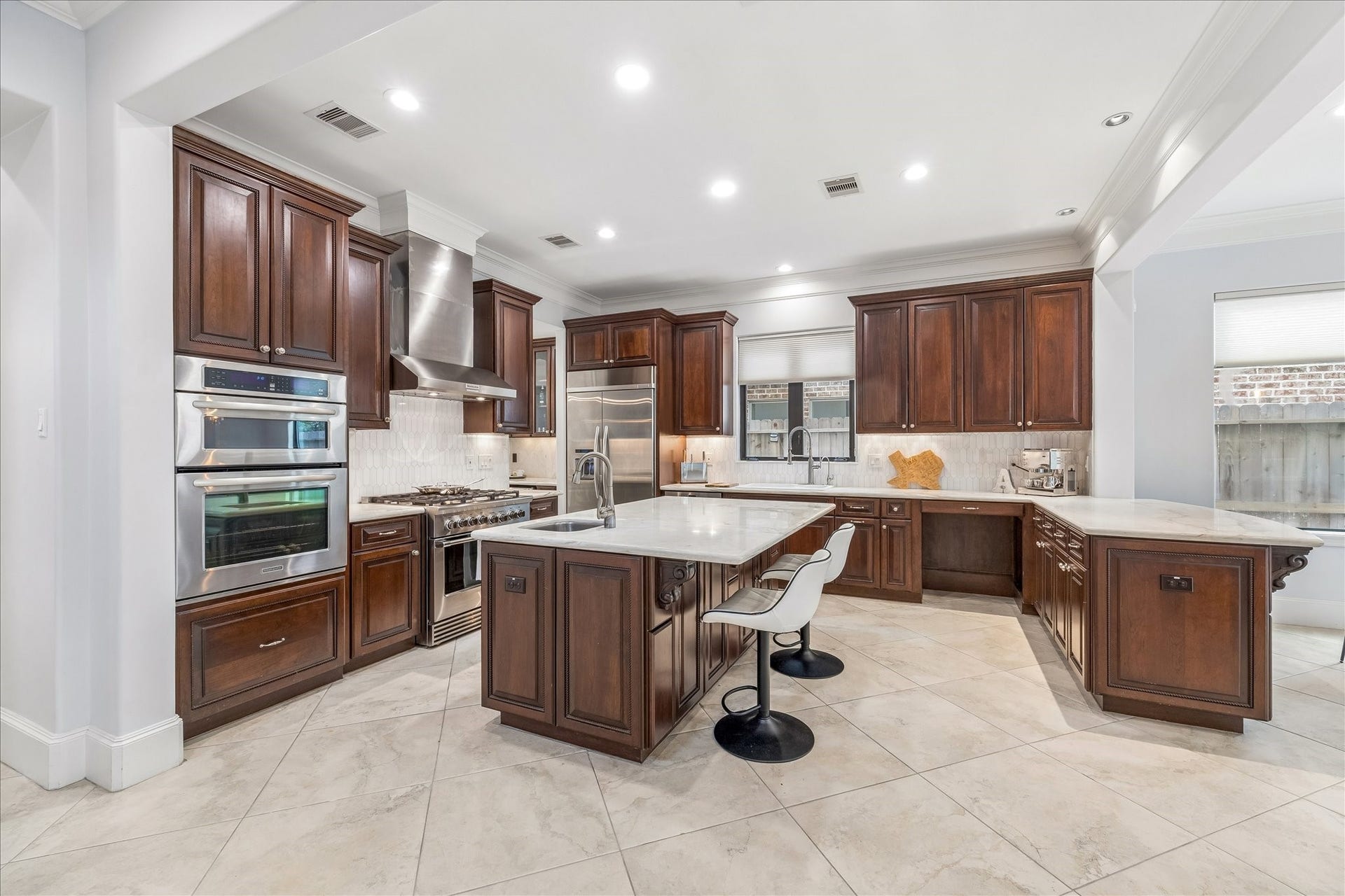 4022 Coleridge Street, West University Place, TX 77005 Expansive kitchen layout offering abundant prep space, marble backsplash, marble countertops, custom cabinetry, and stainless appliances.