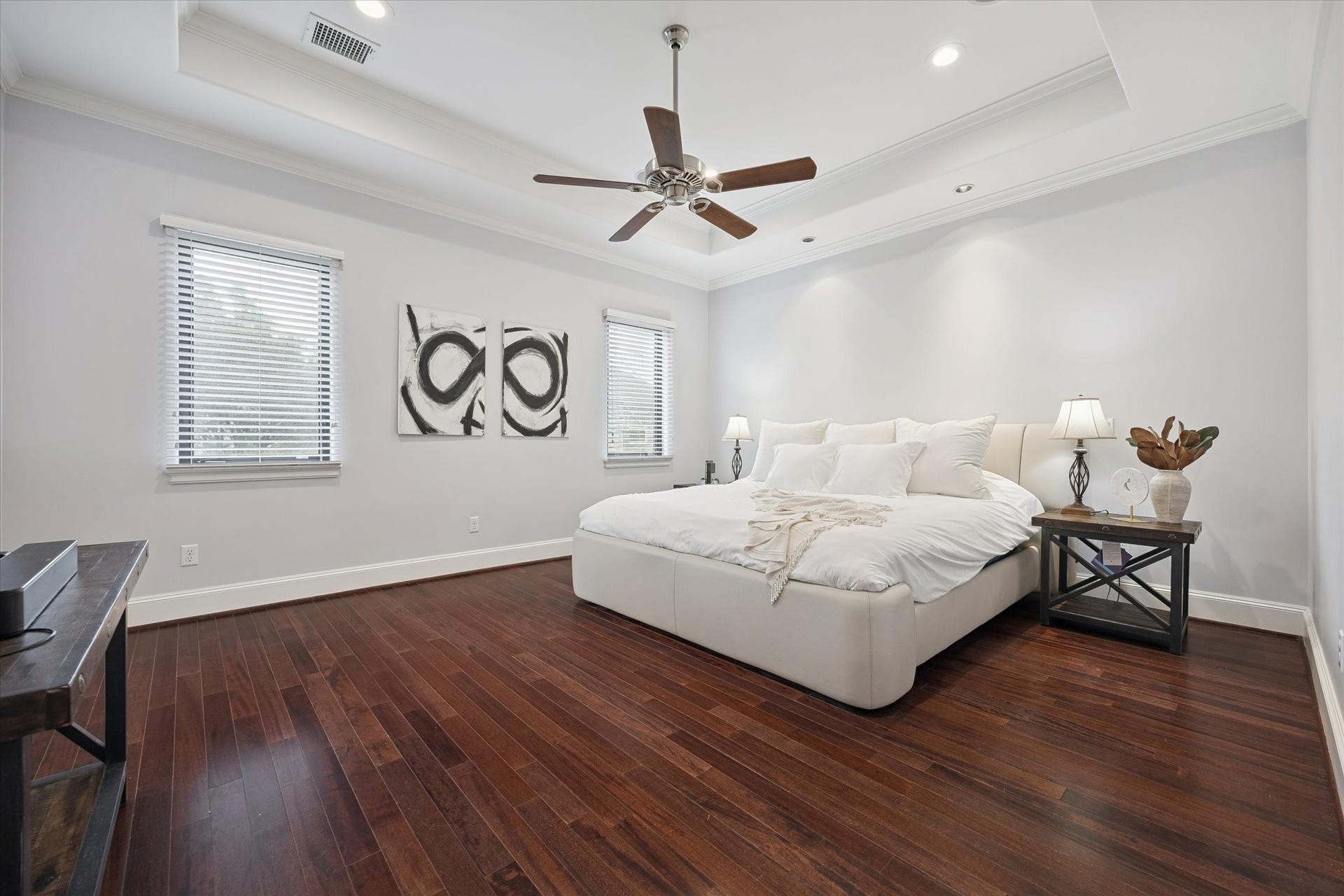 4022 Coleridge Street, West University Place, TX 77005 Spacious and serene primary suite featuring rich hardwood flooring, tray ceilings with elegant lighting, and large windows that fill the room with natural light. This inviting retreat offers generous space for a sitting area and provides a peaceful escape within the home.