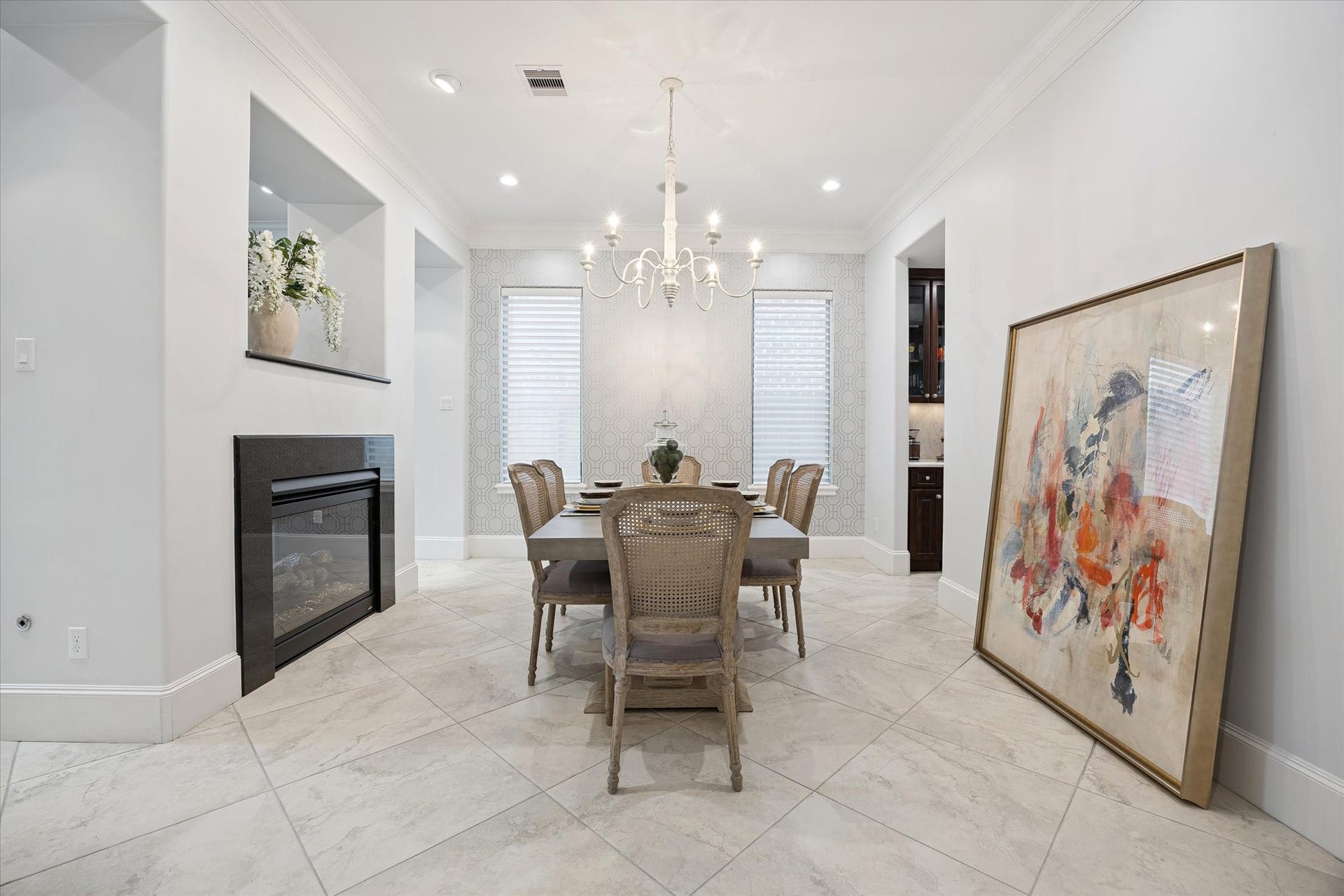 4022 Coleridge Street, West University Place, TX 77005 Formal dining room with designer chandelier, fireplace feature wall, crown molding, recessed lighting, and elegant architectural detailing.