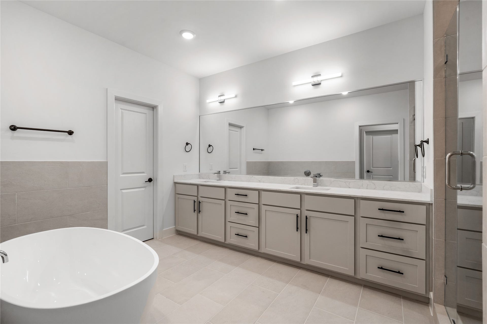 5016 Schuler Street, Houston, TX 77007 Spa-inspired primary bathroom standalone soaking tub, quartz double vanity with extended mirror, LED vanity lighting bars, and frameless glass shower enclosure.