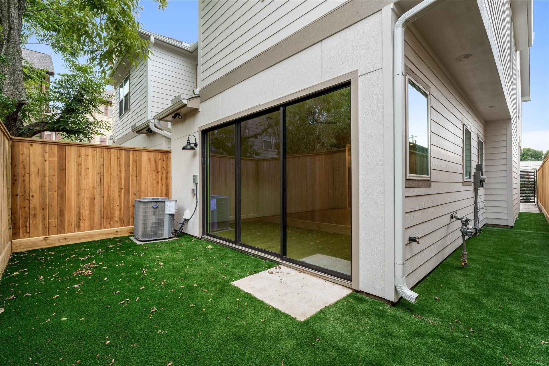 5016 Schuler Street, Houston, TX 77007 Private side courtyard low-maintenance artificial turf, privacy fencing, direct glass sliding door access, and covered exterior entry.