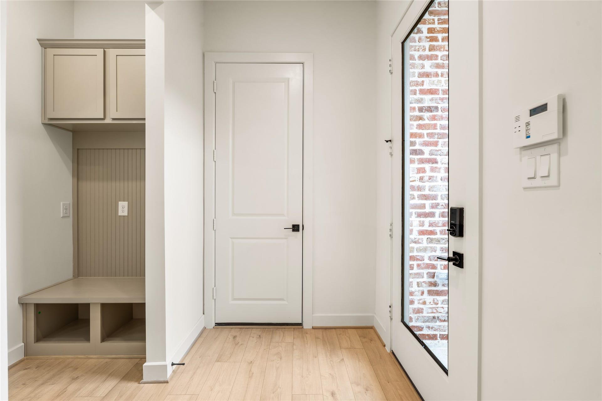 5016 Schuler Street, Houston, TX 77007 Thoughtful mudroom drop zone custom built-in bench seating, storage cubbies, upper cabinets, and glass-paneled front entry door.
