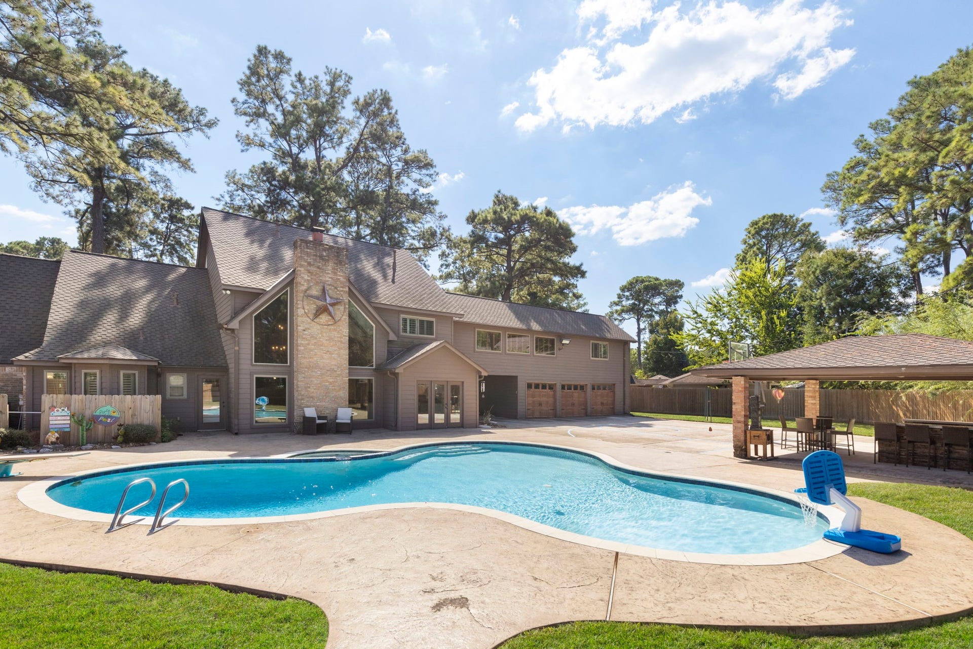 8202 Forest Ridge Road, Spring, TX 77379 Sparkling pool & spa with diving board, huge covered summer kitchen, basketball court and more all with tree top nature views.