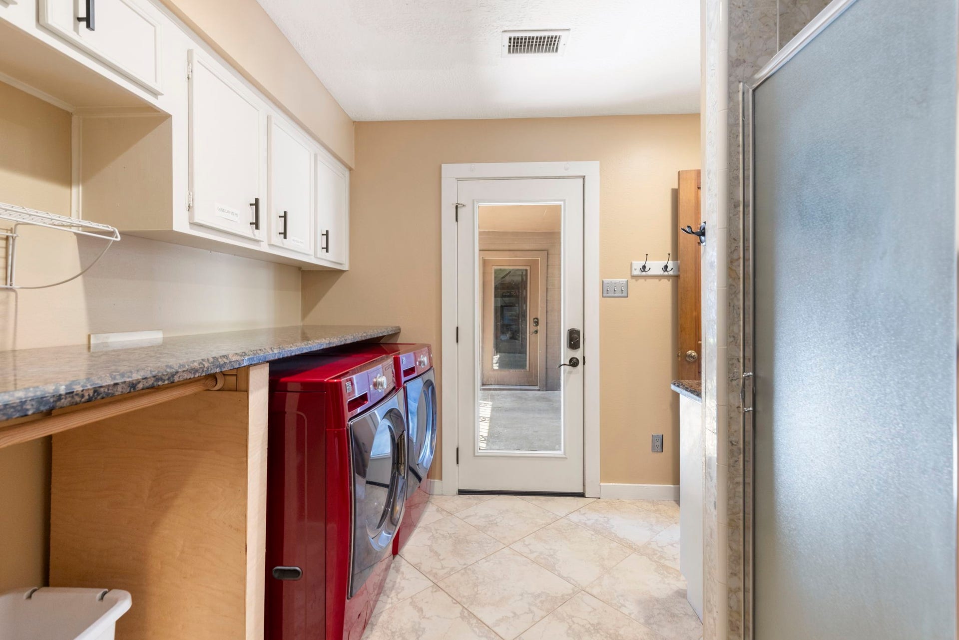 8202 Forest Ridge Road, Spring, TX 77379 Large utility room with incredible storage, broom closet, granite countertops and direct access to the porte cochere and garage.