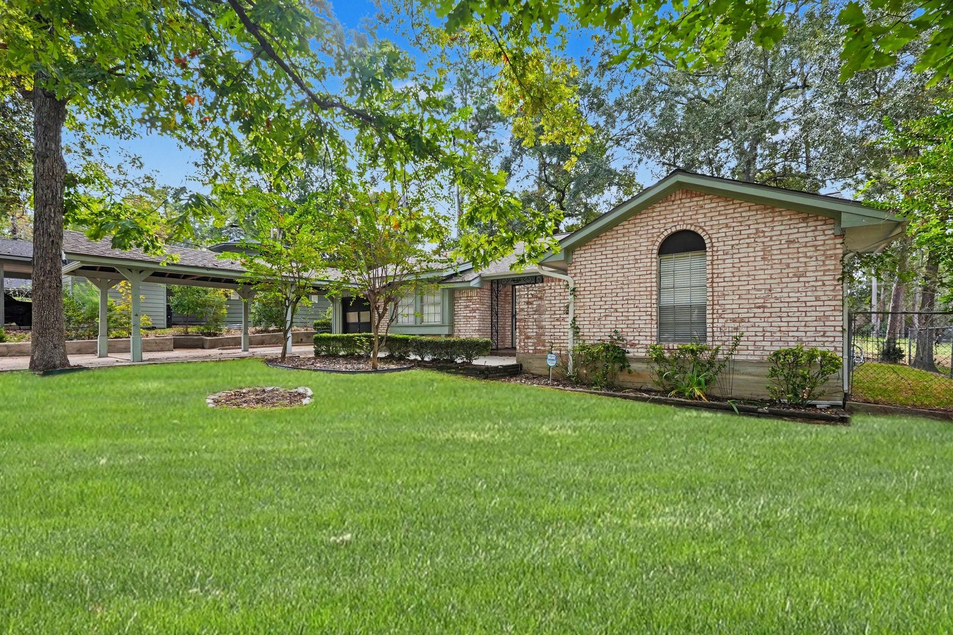 429 Deep Dale Lane, Conroe, TX 77304 This extended covered carport provides convenient additional parking leading directly to a garage with extra storage space.