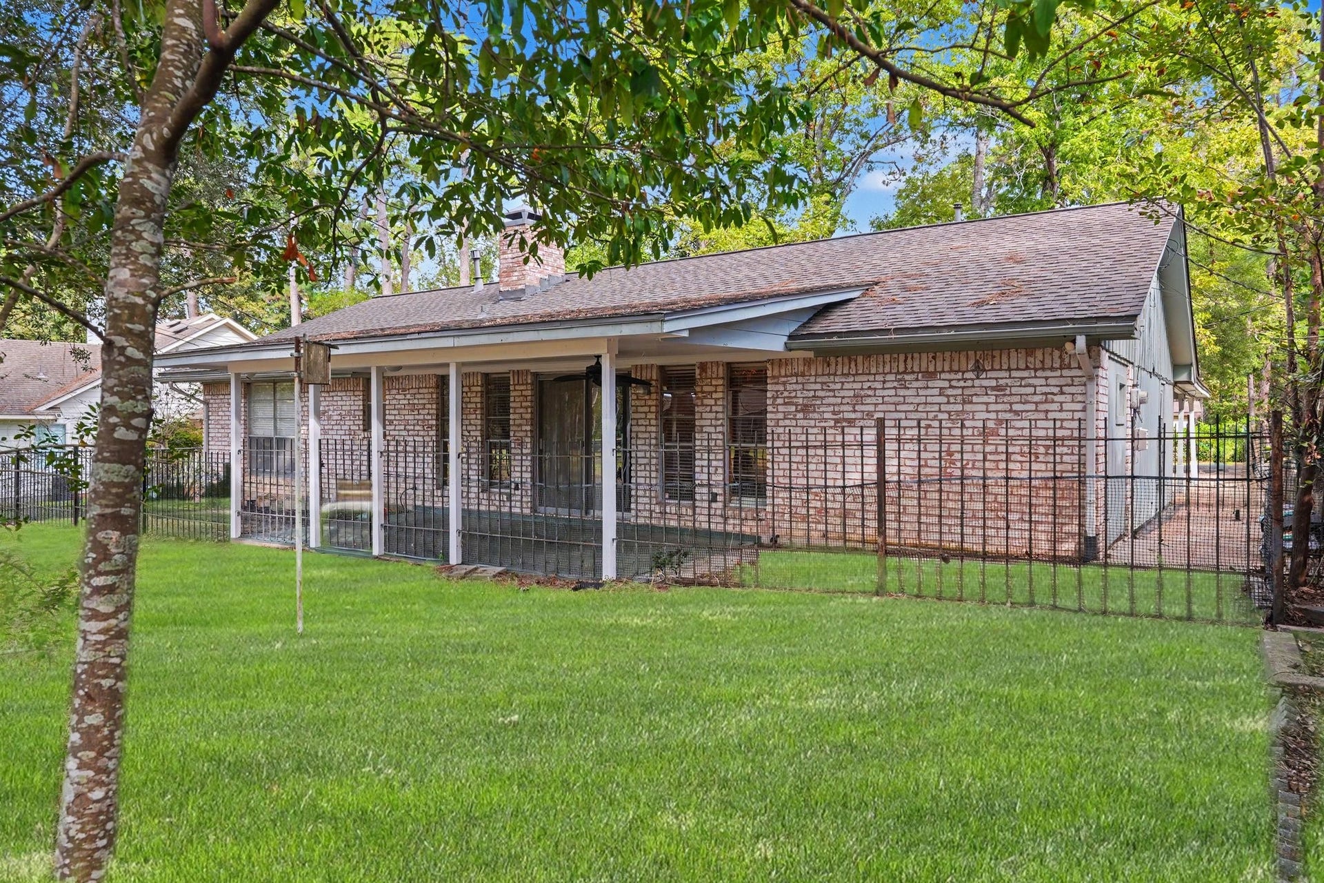 429 Deep Dale Lane, Conroe, TX 77304 A installed fence creates a private, defined transition between the covered patio and greenspace, providing a seamless buffer from the golf course.