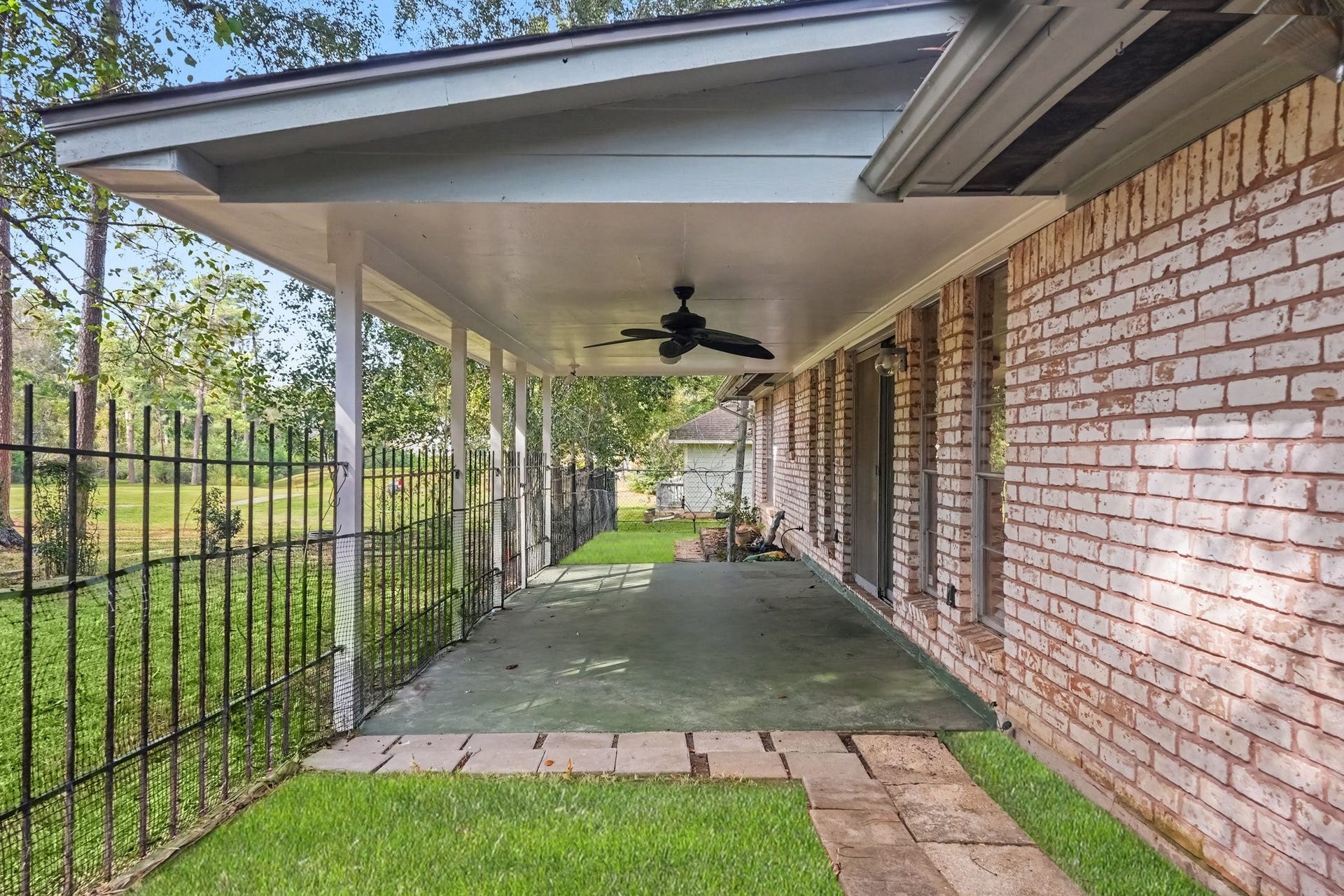 429 Deep Dale Lane, Conroe, TX 77304 This home features sliding doors that open onto a spacious, covered patio equipped with a ceiling fan, perfect for enjoying breezy Texas summer nights overlooking the golf course!