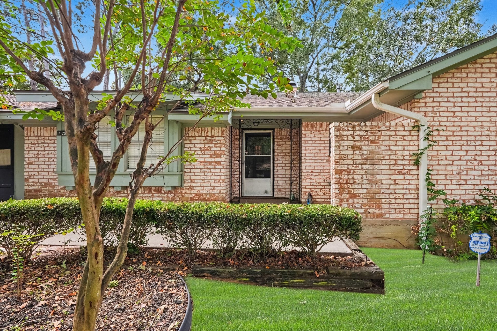 429 Deep Dale Lane, Conroe, TX 77304 Spacious front patio tucked behind lush landscaping for added privacy, featuring a secure storm door paired with the main entry to allow for plenty of natural light.