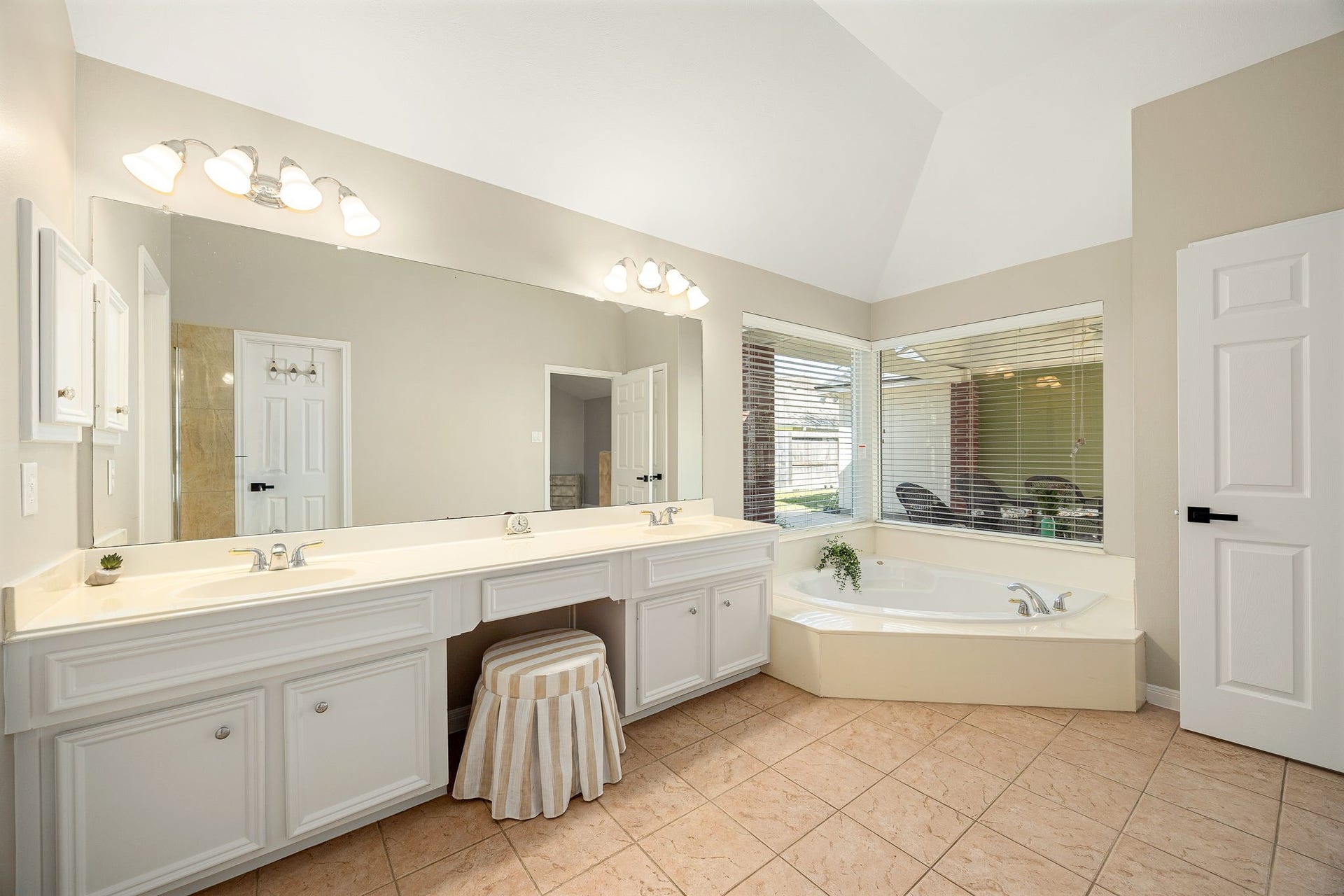 8327 E Copper Village Drive, Houston, TX 77095 The ensuite primary bath offers a corner soaking tub paired with a double-sink vanity, perfect for unwinding after a long day.