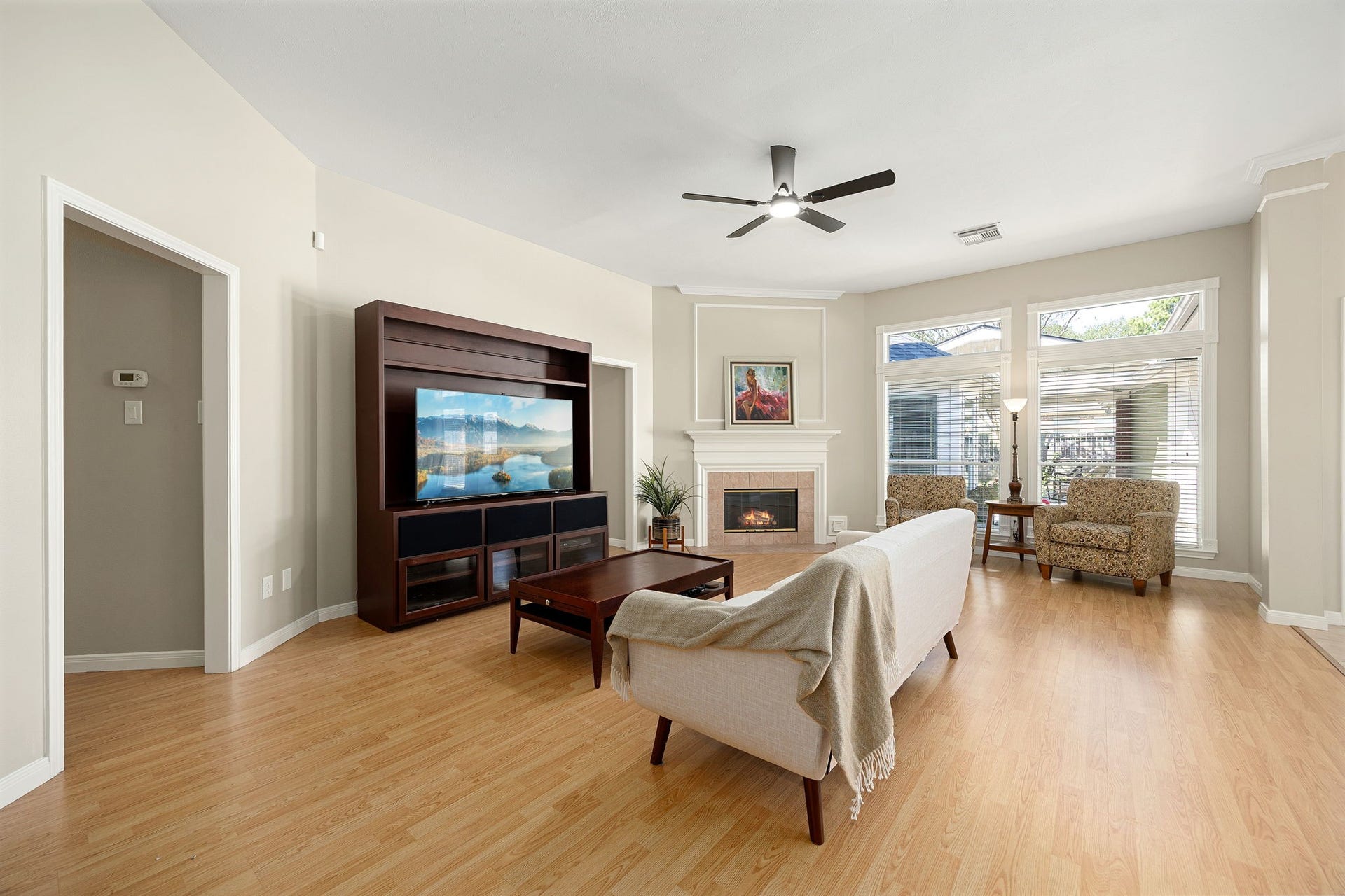 8327 E Copper Village Drive, Houston, TX 77095 The living area centers around a cozy corner fireplace, complete with a ceiling fan and large windows that bring in plenty of natural light.