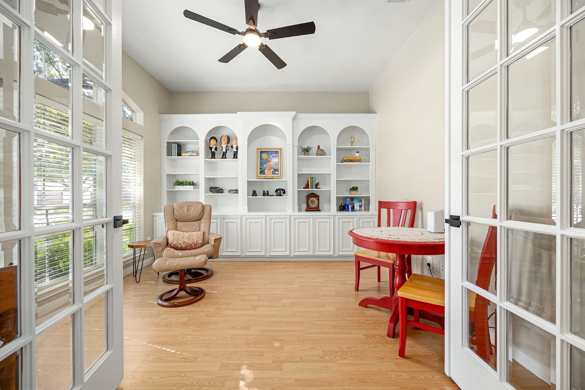 8327 E Copper Village Drive, Houston, TX 77095 Just off the foyer, a private home office features a ceiling fan and custom built-in bookcase with arched niches, framed by elegant French doors.