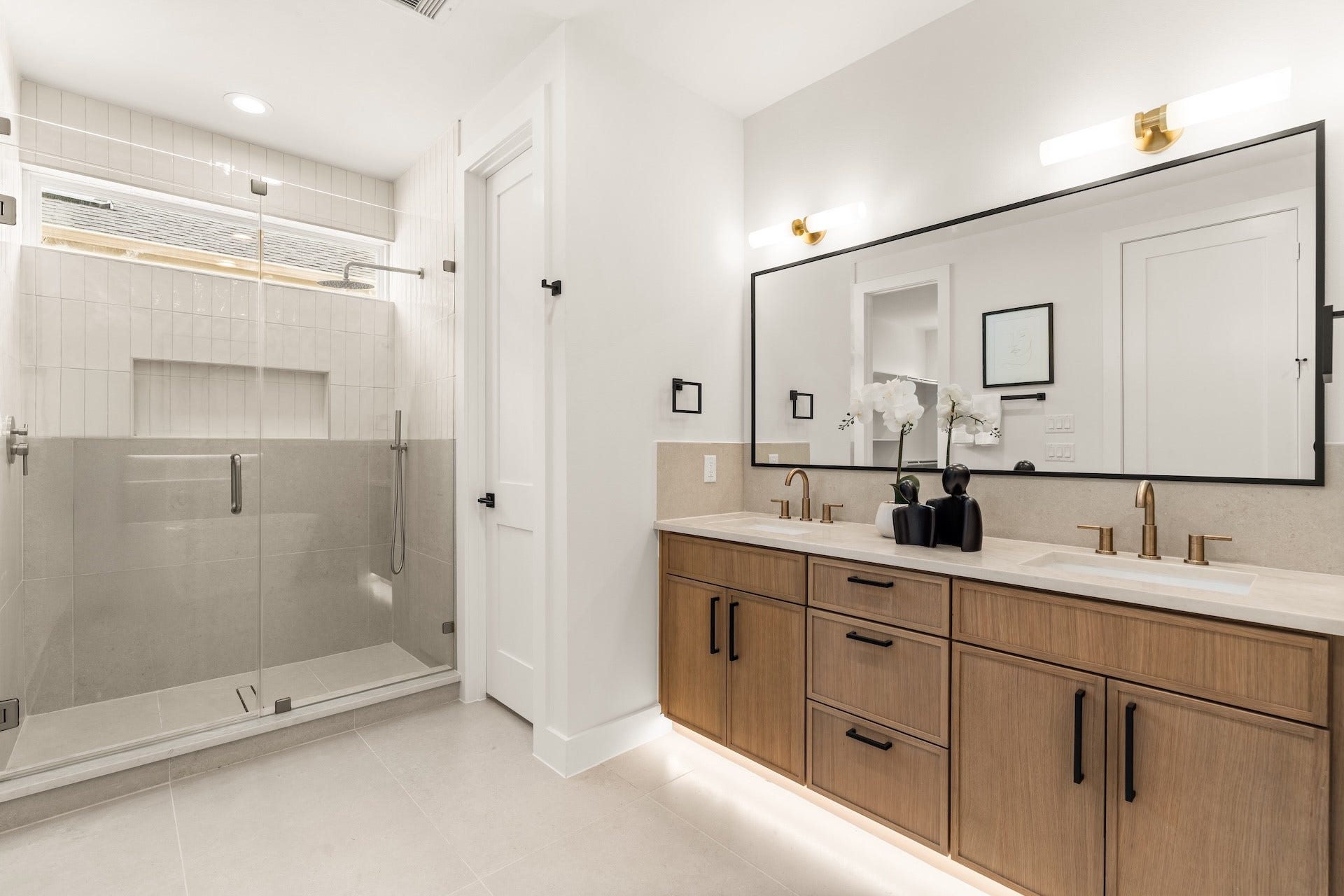 Deluxe primary bath highlighting an expansive dual vanity and frameless glass walk-in shower.
