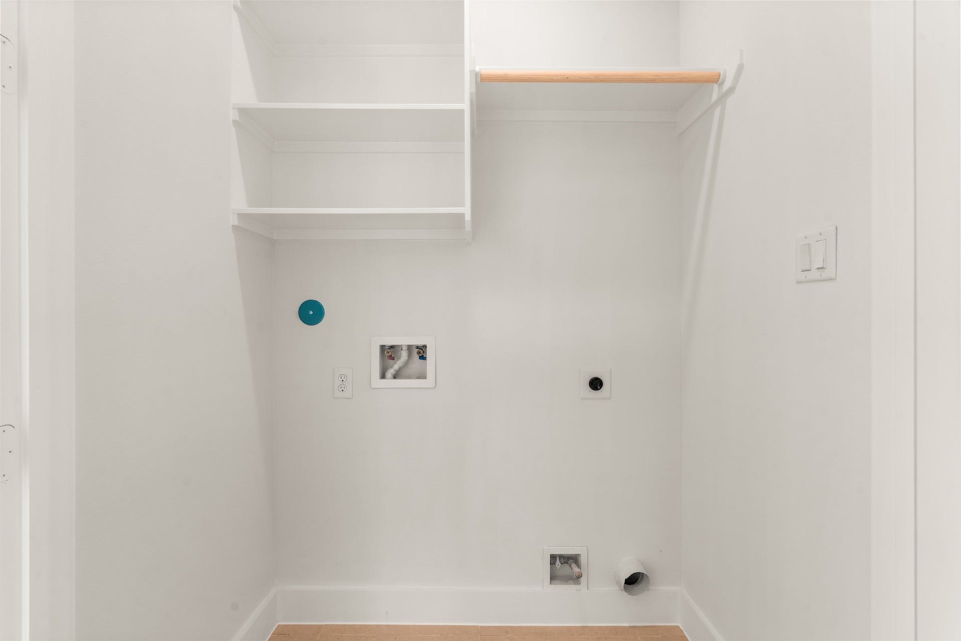 Dedicated second-floor laundry room with built-in storage shelving and full-size hookups.