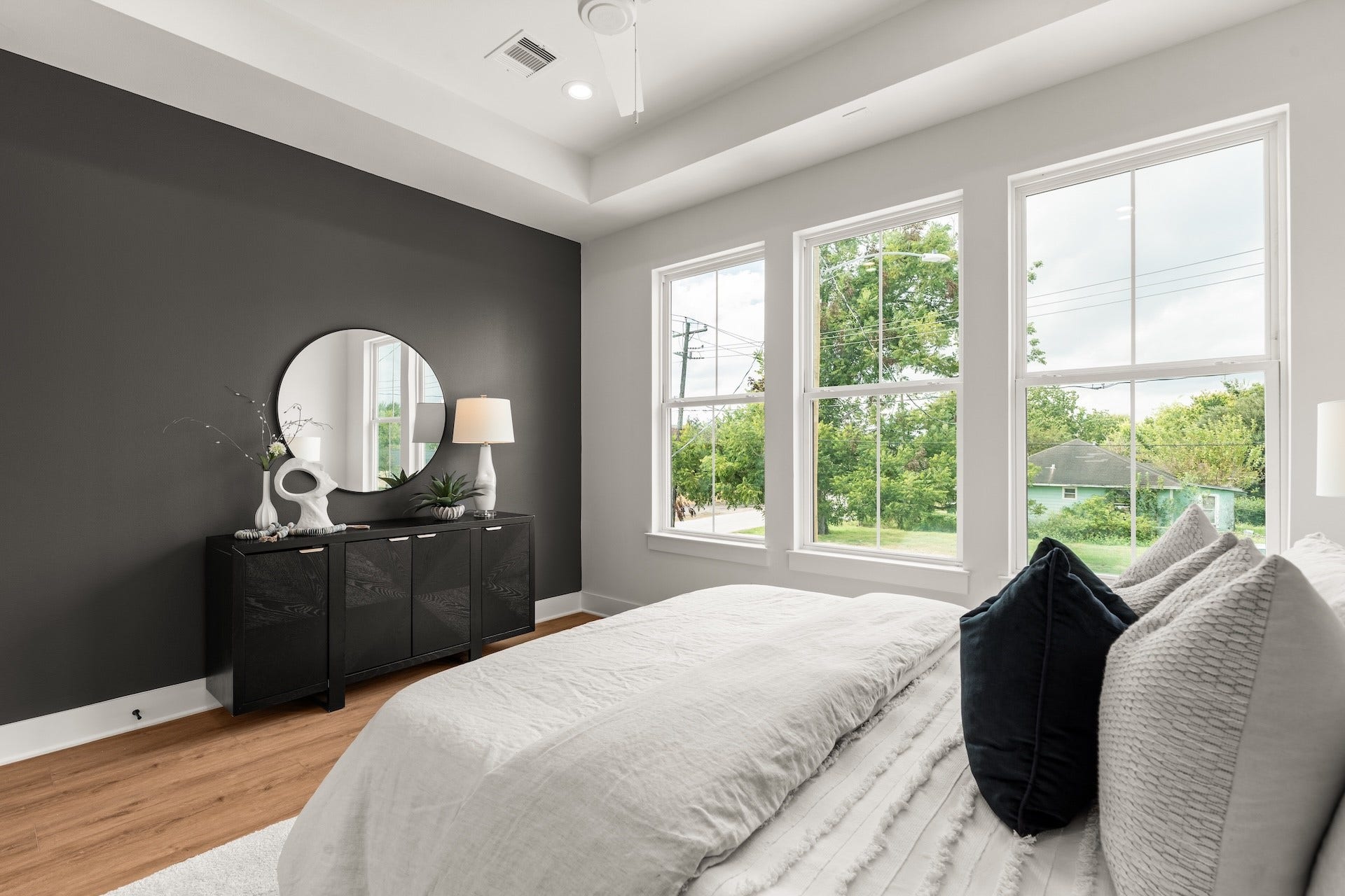 Luxurious primary suite featuring high tray ceilings and expansive windows for a sunlit retreat.