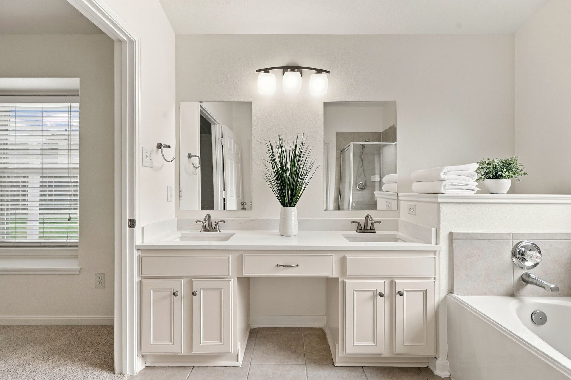 This beautifully updated space showcases double rectangular undermount sinks, two separate mirrors, coordinating fixtures and hardware, and ample storage space beneath the countertops. The thoughtful updates create a polished and cohesive look throughout the Primary Bath.