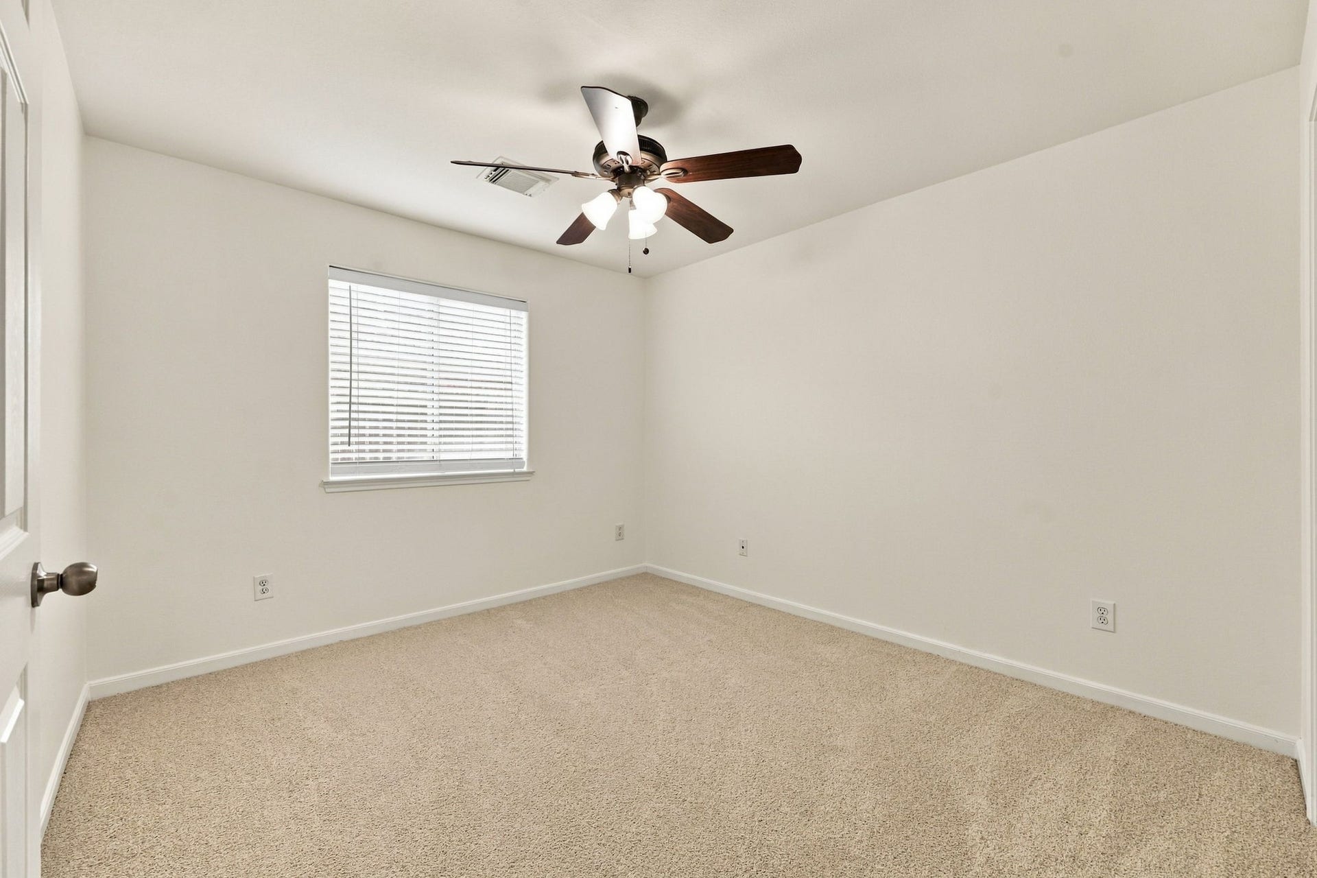 This first-floor Bedroom features newly installed carpet, a large window with 2-inch blinds, and an oil-rubbed bronze five-blade ceiling fan. Convenient access to a Full Bath adds functionality and makes this room ideal for family members or guests.