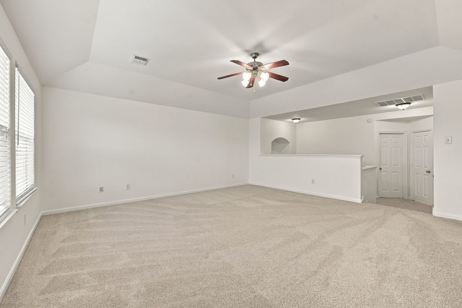 Looking from the opposite side of the Game Room, this view highlights the stairway leading upstairs. Two additional doors provide access to the fourth Bedroom and a Full Bath, creating a private and functional upstairs retreat.