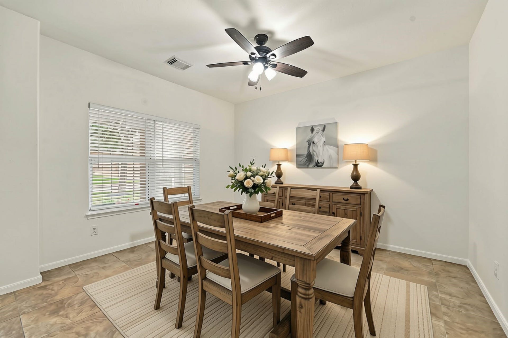 The spacious Formal Dining room offers versatility and could easily serve as a Home Office or additional living space. Features include neutral 18x18 tile flooring, two large windows with 2-inch blinds, and matte black five-blade ceiling fan. (Virtually Staged)