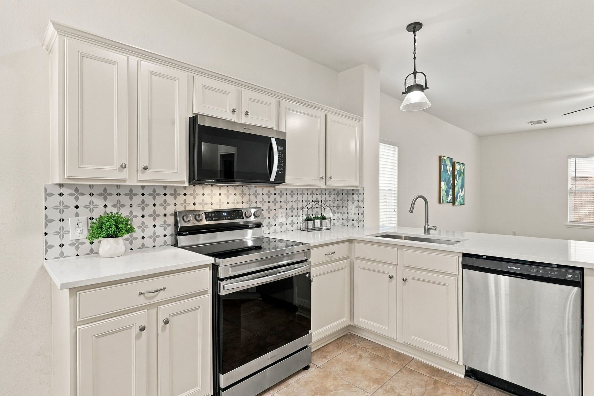 The Kitchen features newer appliances, including a newly installed four-burner electric range. A new stainless steel undermount sink with a gooseneck faucet complements the space, while coordinating cabinet hardware adds a polished finishing touch.