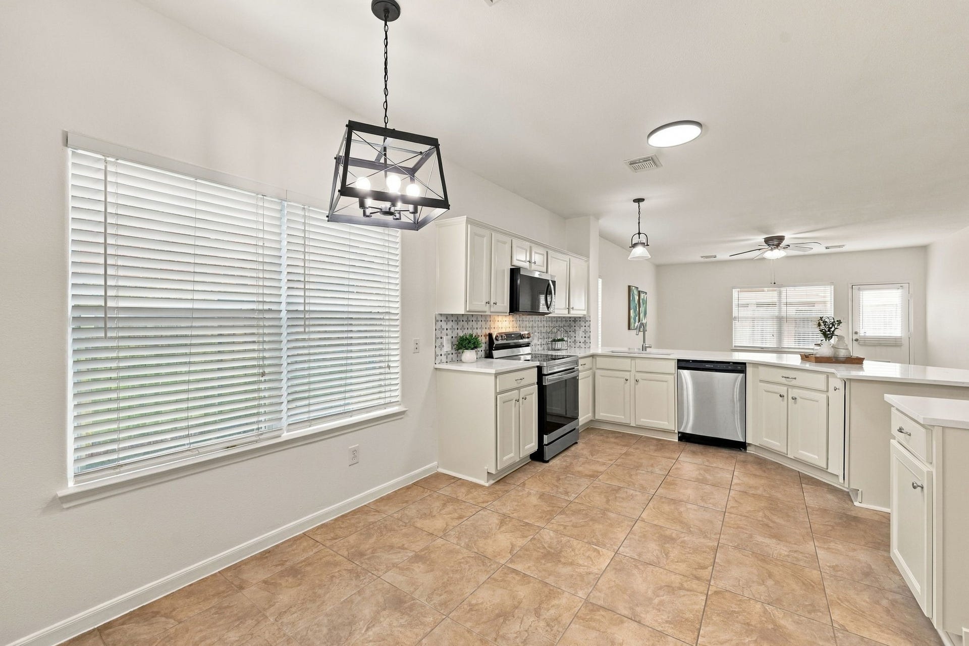 The cozy Breakfast Area features a newly installed matte black birdcage-style chandelier and two large windows that fill the space with natural light. Conveniently located just off the Kitchen, it provides an inviting setting for everyday dining.