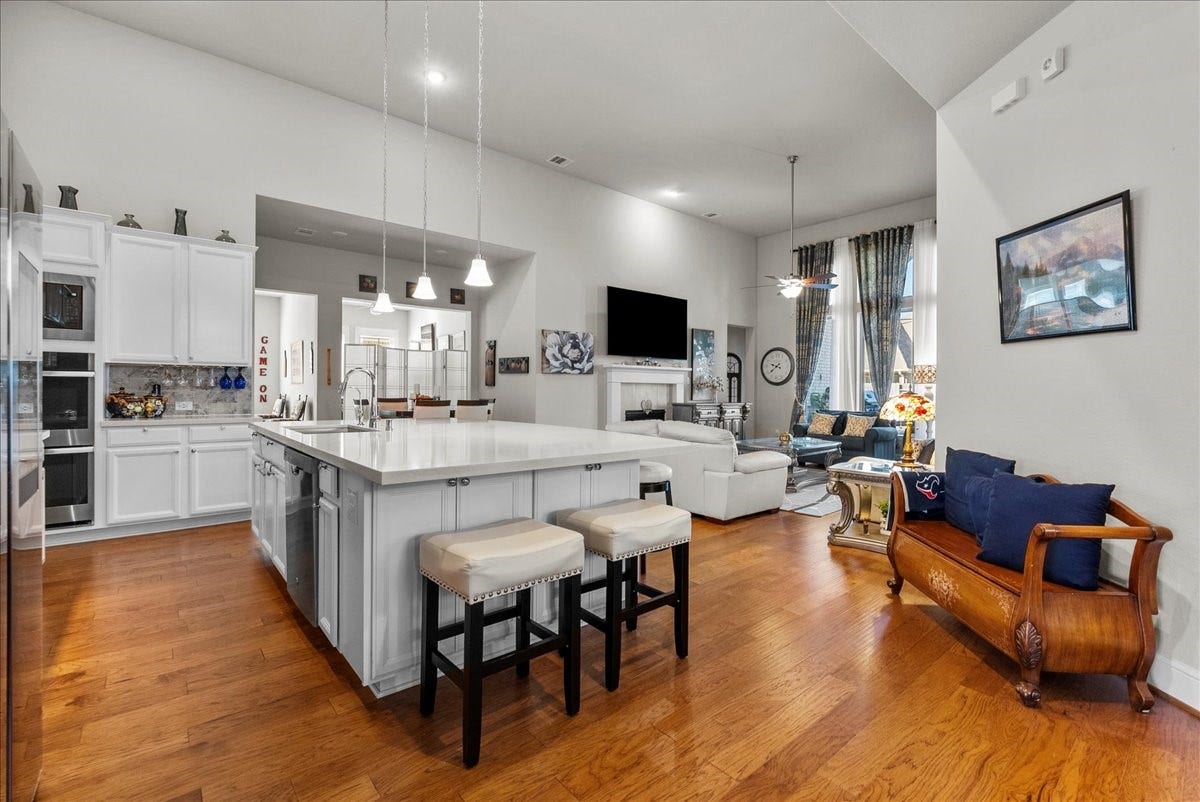 1714 Hartford Mills Lane, League City, TX 77573 Chef's eat-in island kitchen features 42" cabinets with crown molding, quartz countertops, and stainless steel appliances