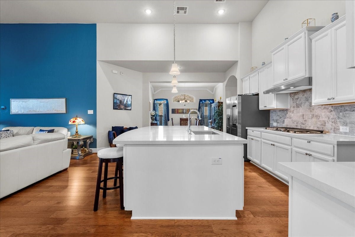 1714 Hartford Mills Lane, League City, TX 77573 Chef's eat-in island kitchen features 42" cabinets with crown molding, quartz countertops, and stainless steel appliances