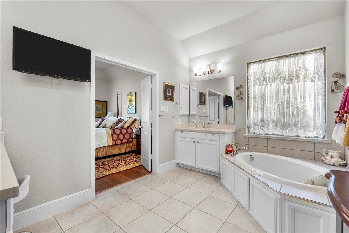 1714 Hartford Mills Lane, League City, TX 77573 The primary en-suite bath offers dual vanities, a walk-in shower, soaking tub and custom walk-in closet