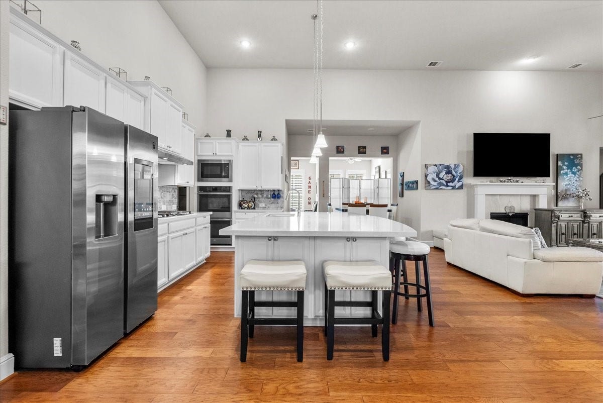 1714 Hartford Mills Lane, League City, TX 77573 Chef's eat-in island kitchen features 42" cabinets with crown molding, quartz countertops, and stainless steel appliances