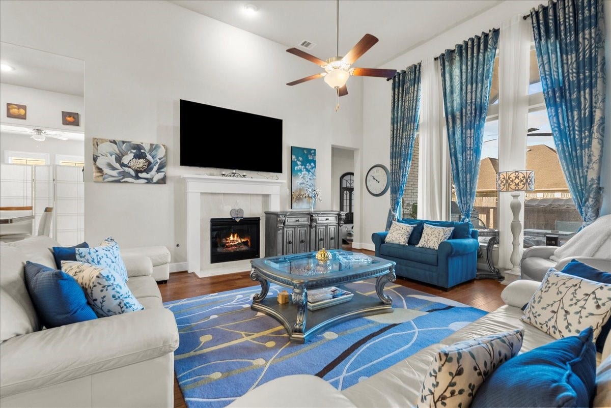 1714 Hartford Mills Lane, League City, TX 77573 The living room features a cozy fireplace, high ceilings and a wall of windows