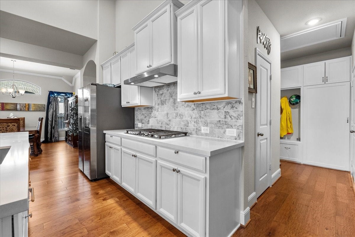 1714 Hartford Mills Lane, League City, TX 77573 Chef's eat-in island kitchen features 42" cabinets with crown molding, quartz countertops, and stainless steel appliances