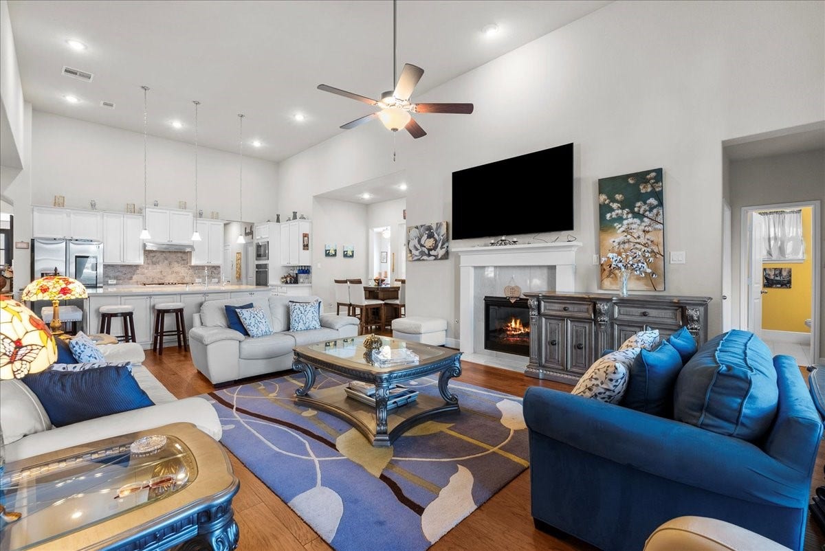 1714 Hartford Mills Lane, League City, TX 77573 The living room features a cozy fireplace, high ceilings and a wall of windows