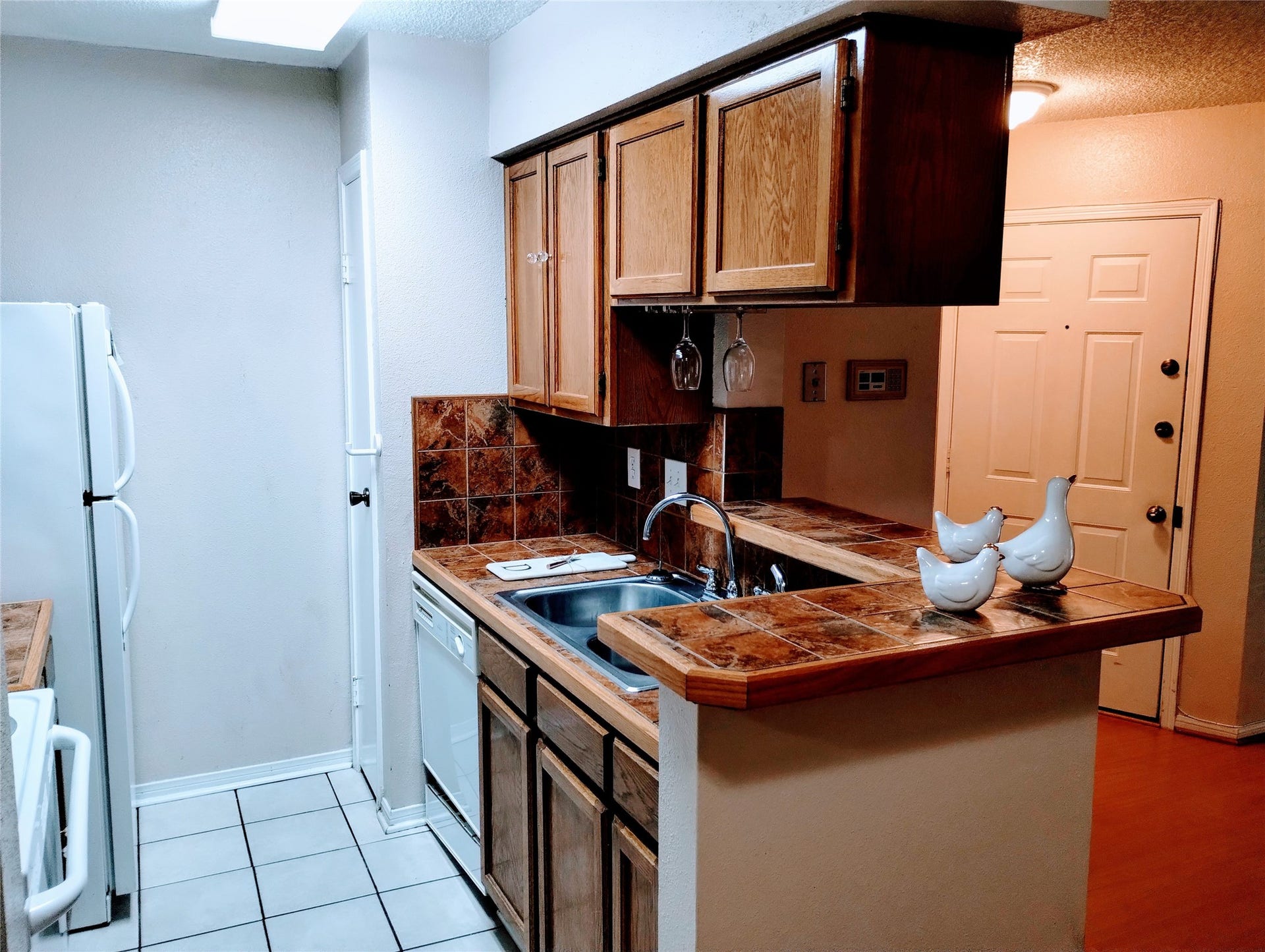 11201 Lynbrook Drive, #3807, Houston, TX 77042 Another view of the KITCHEN showcases the double stainless sink and the pantry to the left of the dishwasher. Notice the FRONT DOOR in the Foyer.