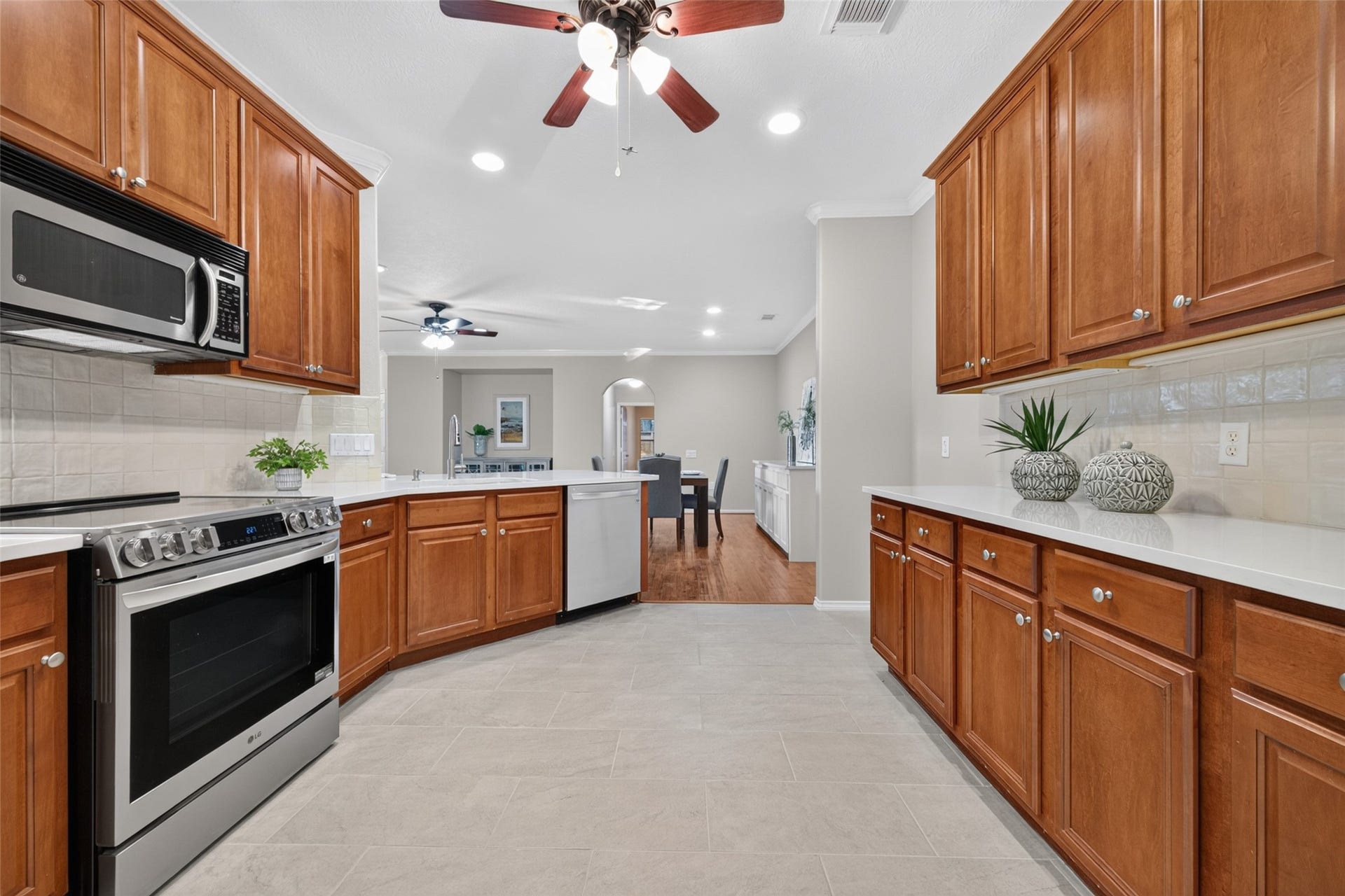 The kitchen features Corian countertops, and stainless-steel appliances, with an open view into the dining and living areas.