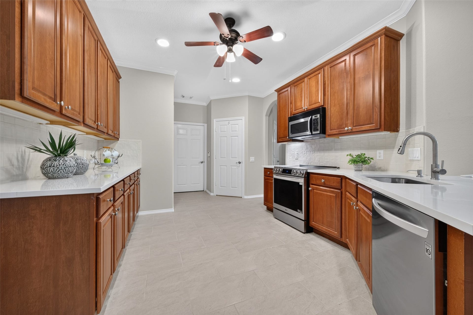 The functional layout flows conveniently into the laundry area with easy access to the garage. This bright kitchen offers abundant cabinet space and beautiful NEW TILE flooring.