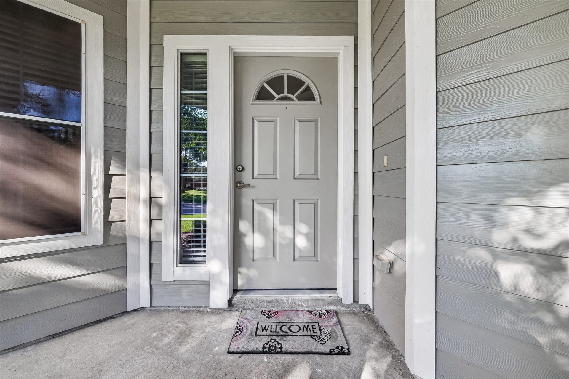 The covered front porch offers a welcoming entry, with a charming front door and decorative glass accents creating a warm first impression.