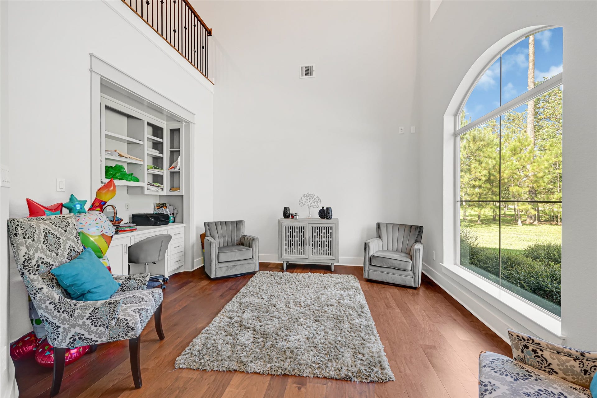 4210 Hidden Winds Drive, Spring, TX 77386 Bright sitting area with a large arched window and wood flooring.