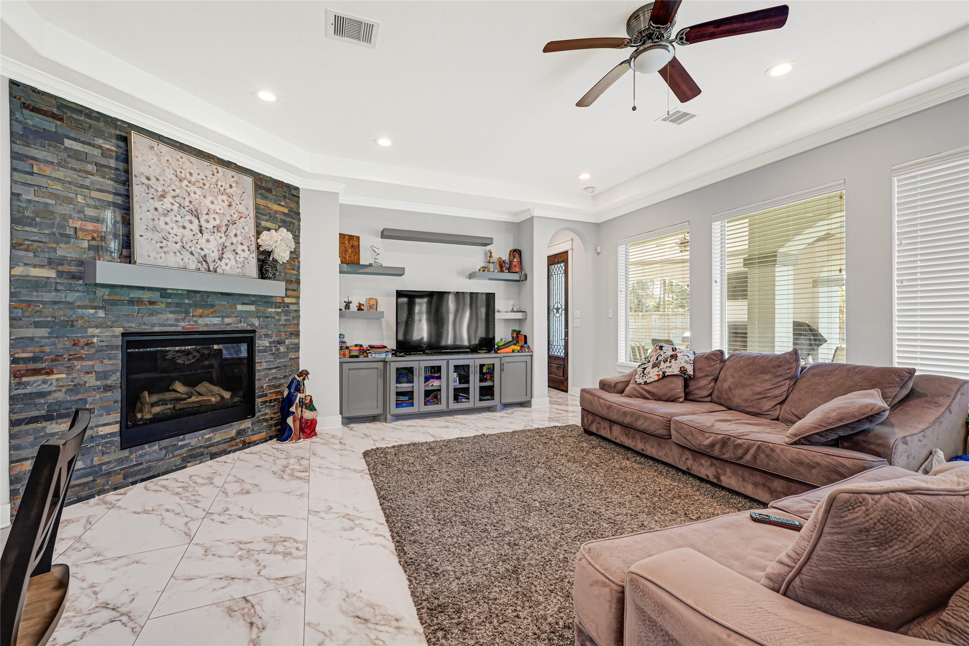4210 Hidden Winds Drive, Spring, TX 77386 Spacious family room features a fireplace and windows overlooking the backyard.