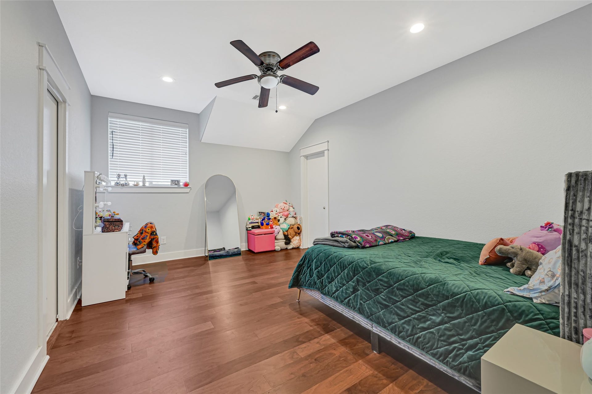 4210 Hidden Winds Drive, Spring, TX 77386 Generous bedroom with wood flooring, a ceiling fan, and room for additional seating.