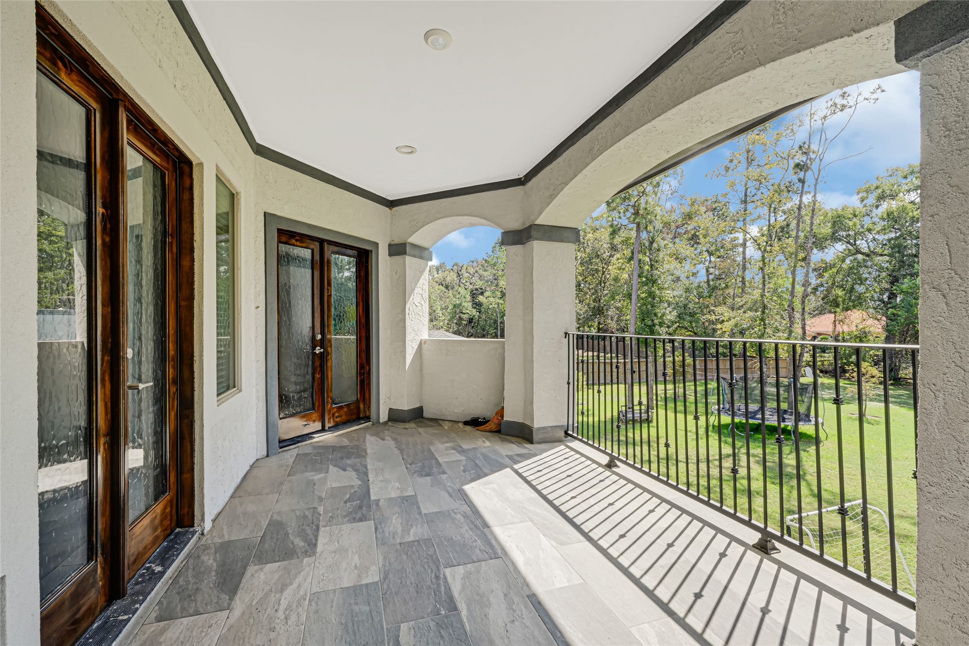 4210 Hidden Winds Drive, Spring, TX 77386 Covered upstairs balcony overlooks the spacious backyard and surrounding trees.