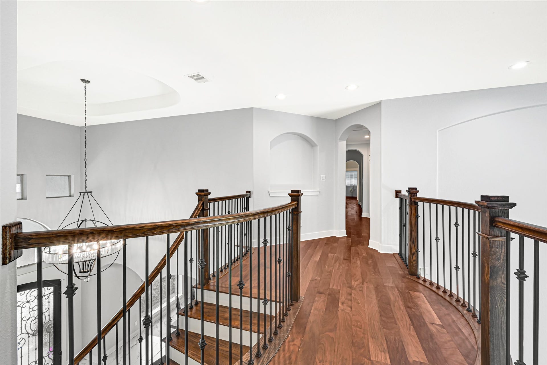 4210 Hidden Winds Drive, Spring, TX 77386 Bright sitting area with a large arched window and wood flooring.