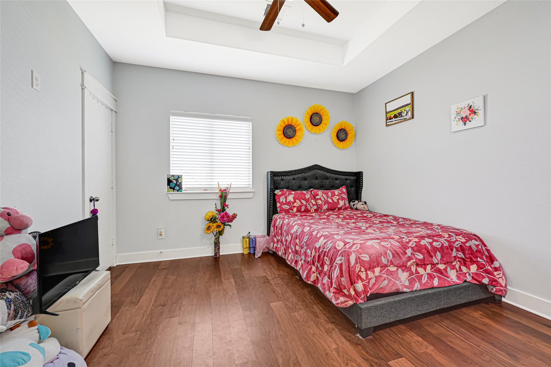 4210 Hidden Winds Drive, Spring, TX 77386 Inviting bedroom features wood flooring, a tray ceiling, and a window for natural light.